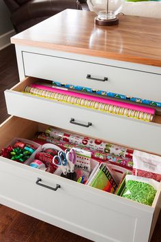 an organized drawer with crafting supplies in it on top of a wooden countertop