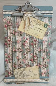 an old fashioned photo frame with flowers and papers attached to the front side of it