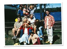 a group of people posing for a photo in front of a lake and some trees