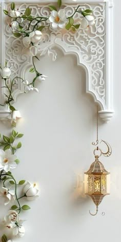 an ornate white wall with flowers and a lantern hanging from it's side on the wall