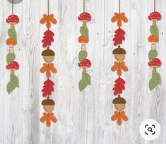 the wooden pegs are decorated with autumn leaves and acorns hanging from strings