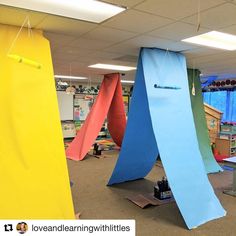 an office with several different colored surfboards hanging from the ceiling and on the ground