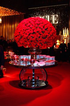 a table topped with lots of red flowers on top of a red carpeted floor