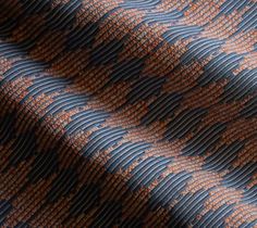 an orange and blue patterned fabric with small waves on it's surface, as well as