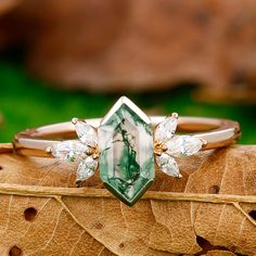 a close up of a ring on top of a leaf