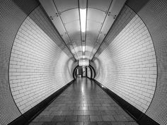 an empty subway tunnel with tiled floors and walls