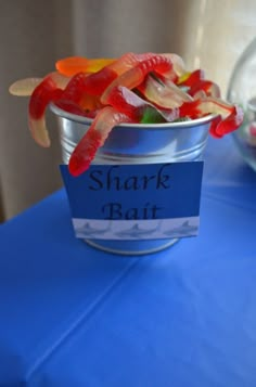 a can filled with gummy bears sitting on top of a blue table