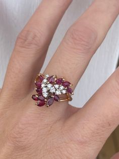 I love the finger coverage with so much sparkle. The shape of the ring flows beautifully on the finger as well.  I can't stop staring at this one. There are 11 very sparkly single cut diamonds measuring 1.5mm each for an approx .17ctw. There are 12 genuine red rubies measuring approx  approx 1.20ctw.  Ring weighs 5.4g and measures 15mm at its widest point for excellent finger coverage. The band tapers down to 2mm at the back of the shank. It is stamped 14k yellow gold. Ring size is 5.25 and sizable.  I can size it for an additional charge. Let me know if you need a quote. Round Cut Diamond Cocktail Ring With Rubies, Dazzling Ruby Ring With Diamond Accents, Cluster Diamond Ring With Vvs Clarity And Ruby, Ruby Ring With Diamond Cluster And Brilliant Cut, Cluster Ruby Ring With Brilliant Cut Diamonds, Cluster Ruby Ring With Rose Cut Diamonds, Diamond Cluster Ruby Ring With Diamond Accents, Marquise Ruby Ring With Diamonds, Dazzling Ruby Diamond Ring