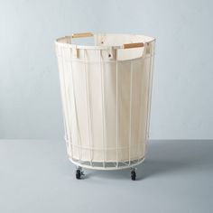 Make laundry day less stressful with this Wire & Fabric Laundry Hamper from Hearth & Hand™ with Magnolia. Designed in a round silhouette with a wired metal frame, this laundry hamper features a soft inner fabric liner to keep your laundry hidden from view. The open-top design comes in handy for sorting through laundry, while the two side wooden handles make it easy to carry. Featuring a white metal frame with a cream fabric liner and natural wooden handles, this laundry basket brings a dash of s Dual Laundry Hamper, Portable Laundry Basket, Jute Laundry Basket, Cute Laundry Basket, Modern Laundry Basket, Laundry Hidden, Laundry Bins, Rolling Laundry Basket, Laundry Basket Storage