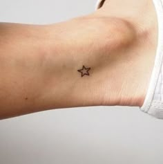 a small star tattoo on the left side of the right arm is shown in black ink