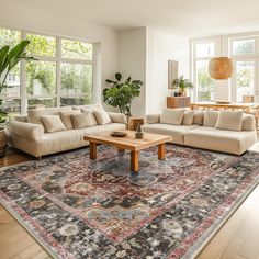 a living room filled with furniture and a large rug on top of a hard wood floor