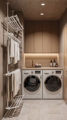 a washer and dryer in a small room with wooden cabinets on the wall