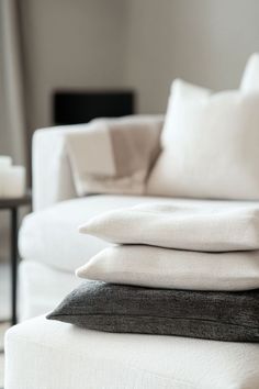 a stack of pillows sitting on top of a white couch