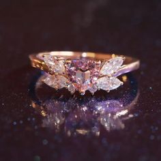 a pink diamond ring sitting on top of a table