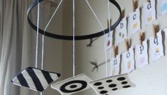 a wind chime hanging from the ceiling in front of a wall with pictures on it