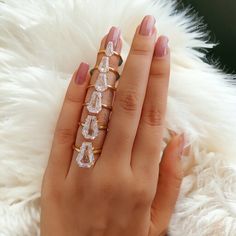 a woman's hand with five rings on it and one ring has three diamonds