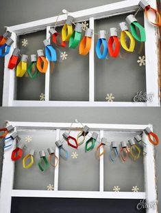 two windows decorated with colorful paper scissors and snowflakes hanging from the window sill