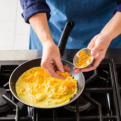 a person cooking food in a pan on the stove