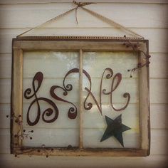 an old window with the word sale written on it and a star hanging from the side