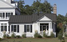 a white house with black shutters and a clock tower