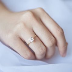 a woman's hand with a diamond ring on it