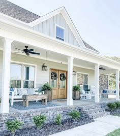 the front porch of a white house with blue accents