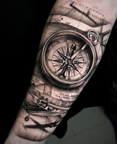 a man's arm with a compass and plane on it, in black and white