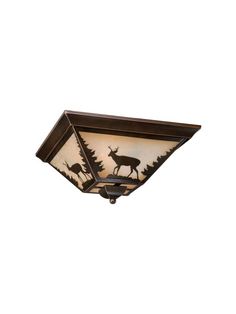 a ceiling light with deer silhouettes on the side and trees in the back ground