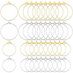 six pairs of gold, silver and white hoop earrings with metal hooks on each side