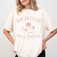 "Cabo Bachelorette Party Shirts Cocktail Club Bach Cabo San Lucas Bachelorette Shirts Beach Bach Bash Personalized Luxury Bachelorette Merch Premium Quality Printed in the USA. HOW TO ORDER ----------------------- 1-) Check and Review all Photos. 2-) Select Your T-Shirt Size from drop down menu. 3-) Choose Your Quantity you want. 4-) Click ADD TO CART. And, you can go back to add more product for your family members or You can complete the checkout process. 5-) Please Click \"Proceed to Check Out\" 6-) Your order will be ready to ship 2-5 Business Day. ABOUT US --------------- We are a husband-and-wife team who believe that beauty is all around us, and we strive to capture it in our designs. Thank you for choosing to shop with us, and we hope you find something that inspires you! For custo Casual Summer Tops For Bachelorette Party, Summer Bachelorette Party Crew Neck Shirt, Summer Bachelorette Party Shirt With Graphic Print, Summer Graphic Print Shirt For Bachelorette Party, Graphic Print Shirt For Summer Bachelorette Party, Graphic Print Shirt For Bachelorette Party In Summer, Summer Crew Neck Shirt For Bachelorette Party, Crew Neck Shirt For Bachelorette Party In Summer, Cabo San Lucas Bachelorette