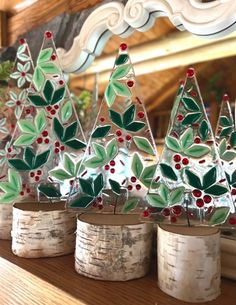 small christmas trees are sitting in vases on a table