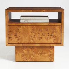 a wooden shelf with two books on it and a magazine rack in the middle that is made out of wood