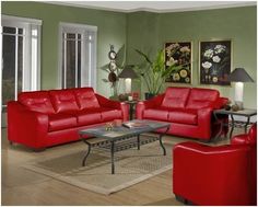 a living room with red leather furniture and green walls