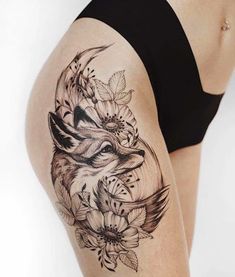 a woman's thigh with a wolf and flowers tattoo on it