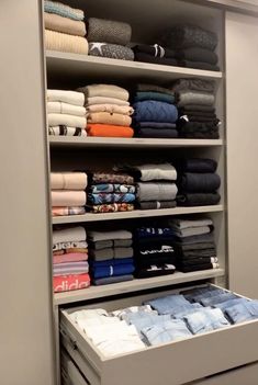 an organized closet with folded clothes and folded shirts