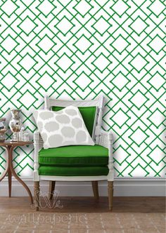 a green chair sitting in front of a wall with an abstract pattern on the wall