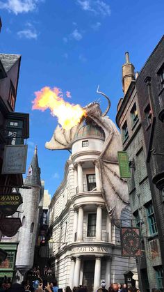 an image of a dragon on the side of a building with fire coming out of it