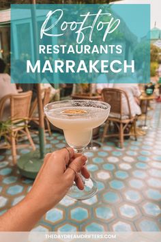 a person holding up a martini glass with the words rooftop restaurant's marrakech