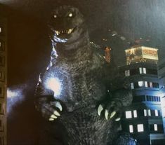 the godzilla statue is lit up at night