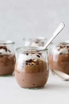 three jars filled with chocolate pudding and topped with whipped cream