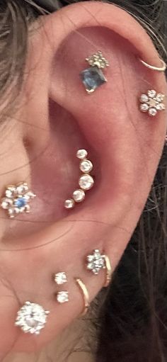 an ear with several different types of piercings