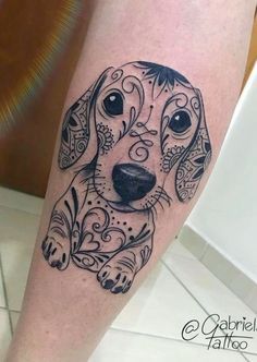 a black and white dog tattoo on the right leg, with an intricate border around it