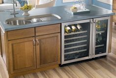 a kitchen with a sink, wine cooler and cabinets