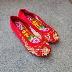 a pair of red shoes with flowers painted on them