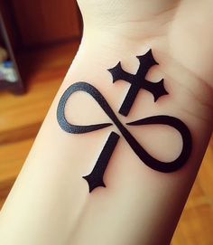 a tattoo on the wrist of a woman with an infinite sign and stars around it