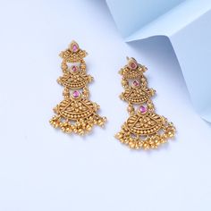 Description Inspired by the shimmering Indian gold jewelry. This Collection is designed to highlight the fine Indian craftsmanship. It is crafted in gold-plated 925 silver with intricate textures and tones. Modern designs adorn you with timeless floral patterns. This jewelry is perfect for wedding and festival events. Created by Paksha design experts, the Swara signature drop earrings gather three floral motifs, coming together in a joyful dance. The pearl drops and pink stones add the right bal Festive Wedding Chandbalis With Elegant Design, Elegant Festive Brass Chandbalis, Festive Brass Earrings, Temple Bridal Earrings With Intricate Design For Festive Occasions, Ornate Gold-plated Chandbali Jewelry, Elegant Brass Chandbalis With Intricate Design, Festive Gold Jewelry With Matching Earrings, Gold Brass Bridal Earrings For Festive Occasions, Elegant Brass Chandbalis For Festivals