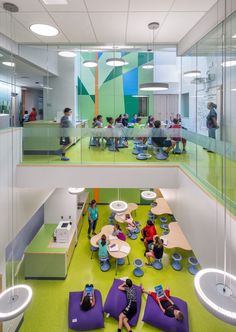 an office with people sitting on bean bags in the middle of the floor and tables