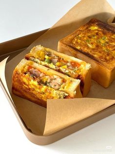 two pieces of bread sitting on top of a brown tray next to another piece of food