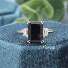 a black and white diamond ring sitting on top of a blue blanket