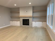 empty living room with fireplace and built - in shelving units on either side of the fire place